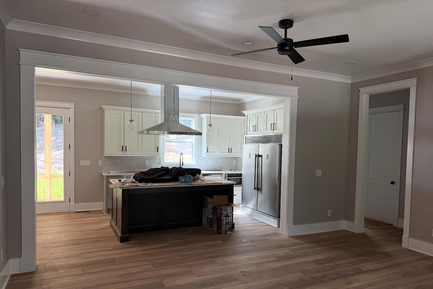 Full kitchen with island, range hood, and paneled refrigeration